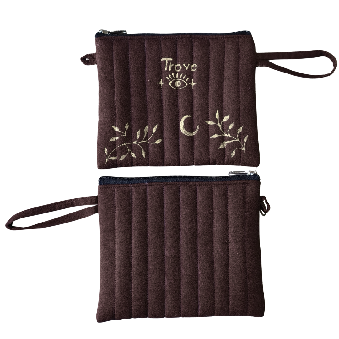 Brown pouch with embroidered designs and 'Trove' branding on a white background