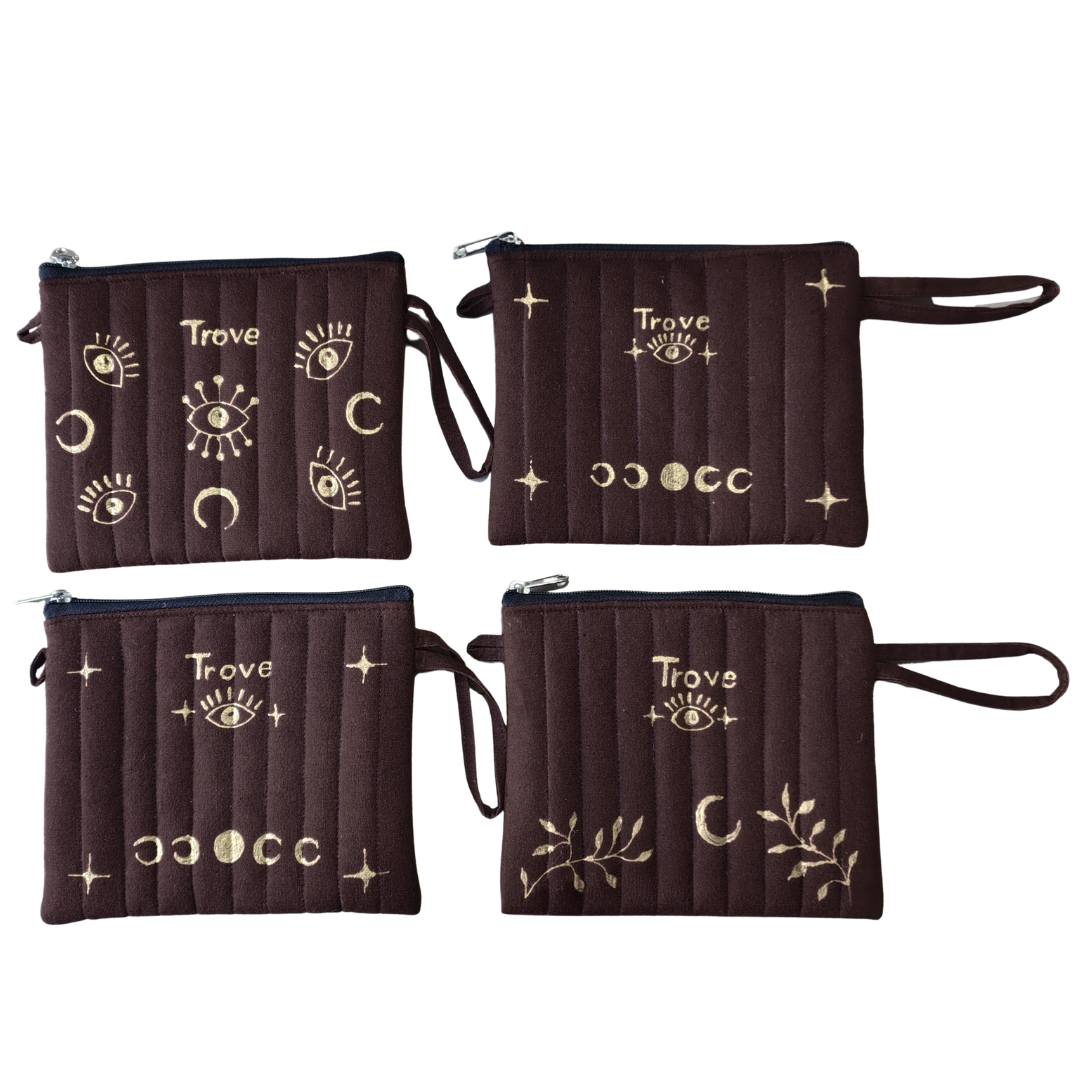 Four brown pouches with gold designs and 'Trove' branding on a white background