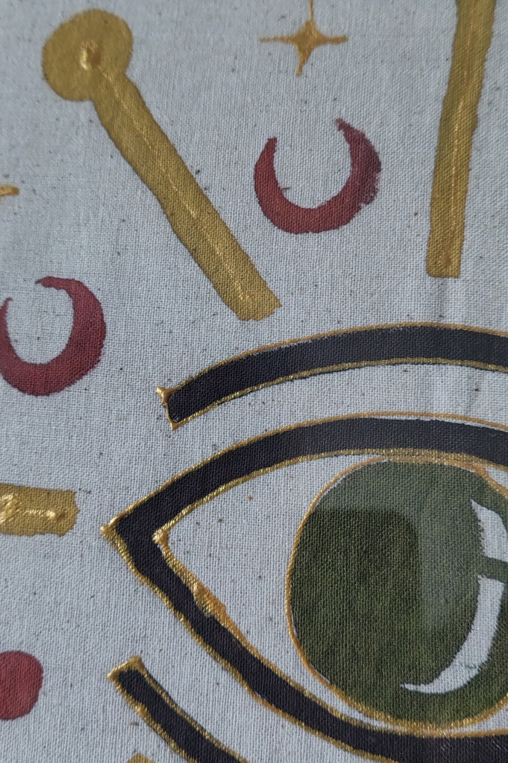 Decorative fabric with eye design, crescent moons, and gold accents on a light blue background