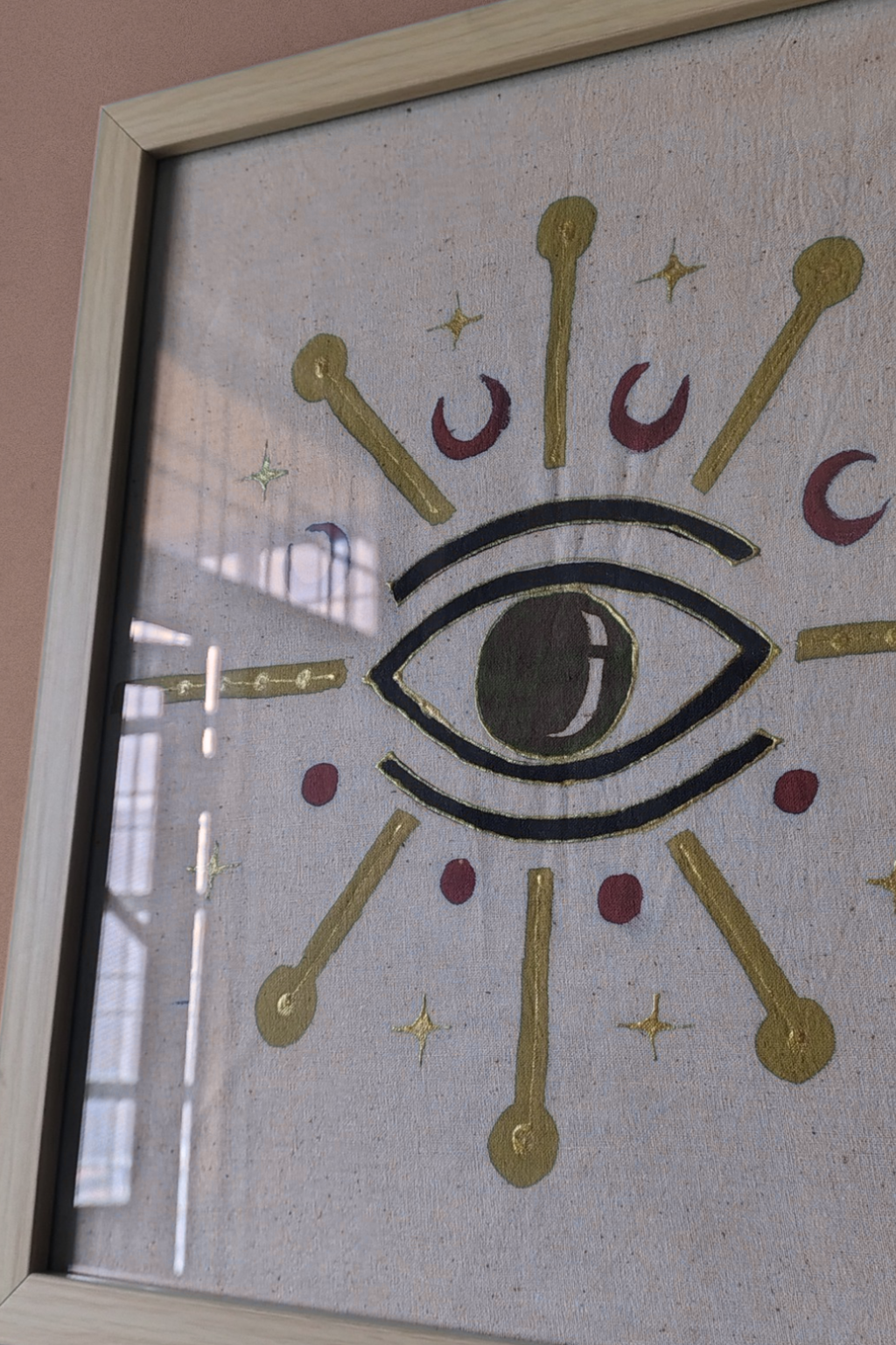 Decorative window with eye design and gold accents on a plain background