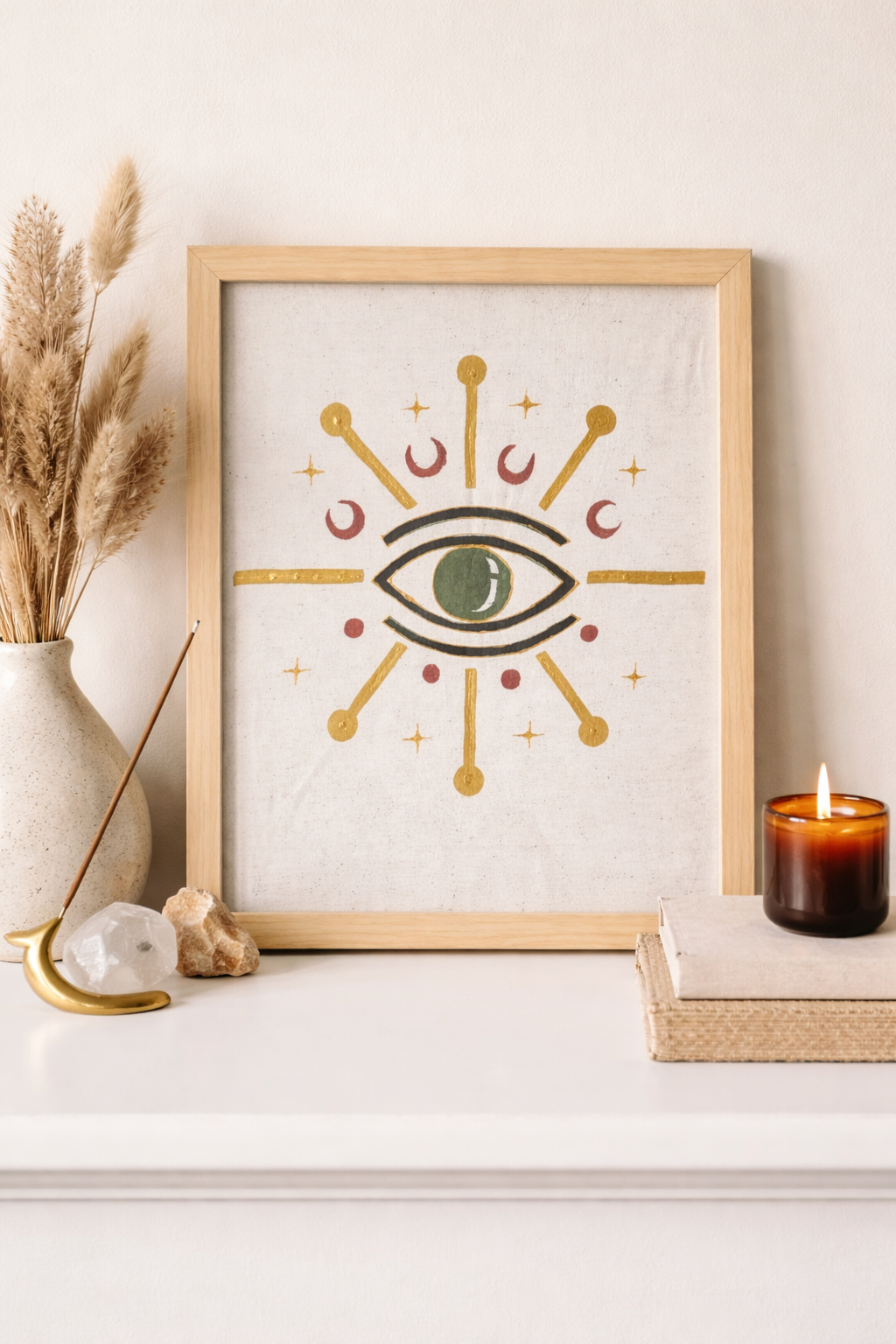 Framed artwork with eye design on a shelf with decorative items
