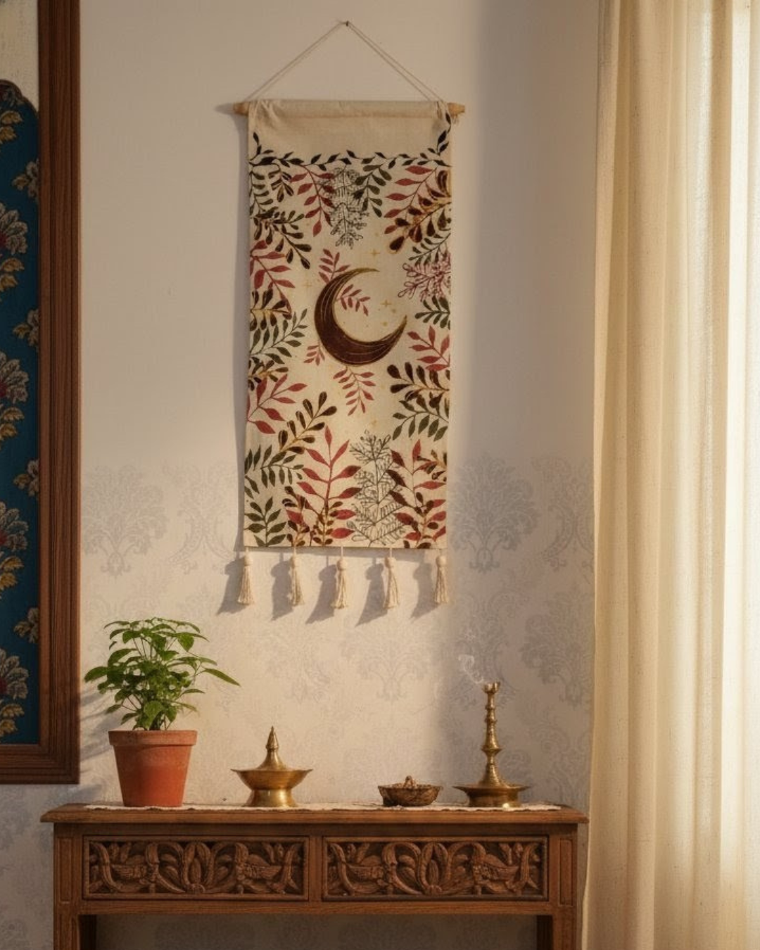 Decorative wall hanging with floral patterns and a moon design, hanging above a wooden console table with decorative items.