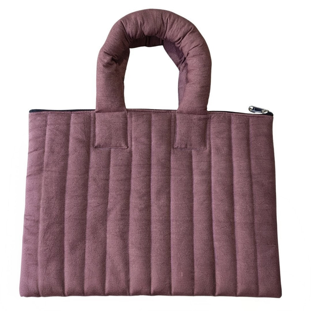 Purple quilted handbag on a white background