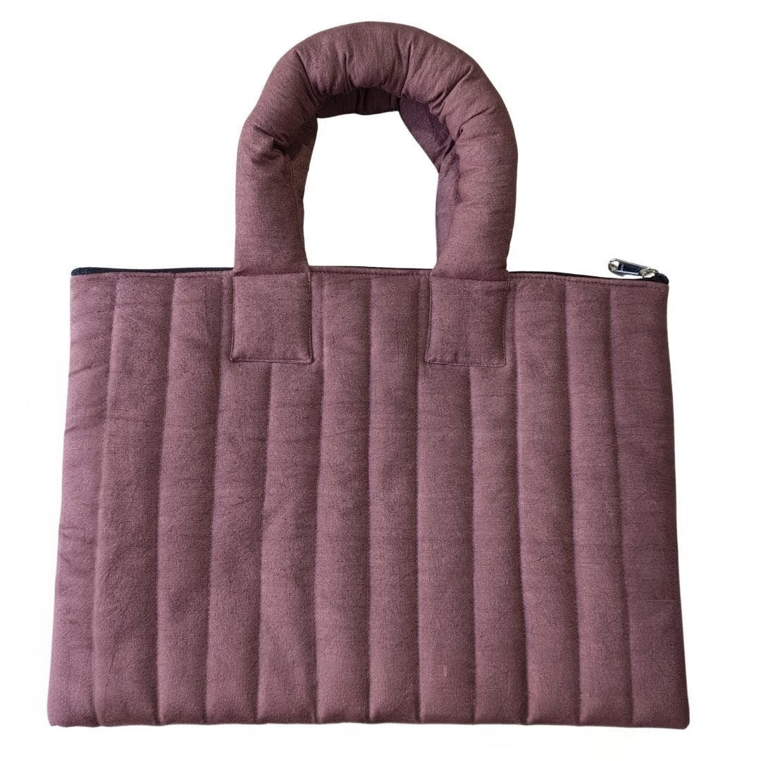 Purple quilted handbag on a white background