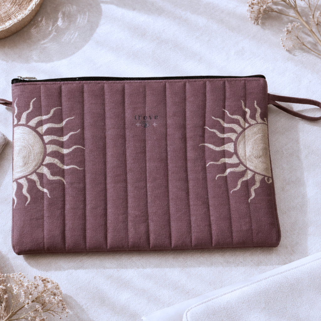 Purple pouch with sun designs on a white surface