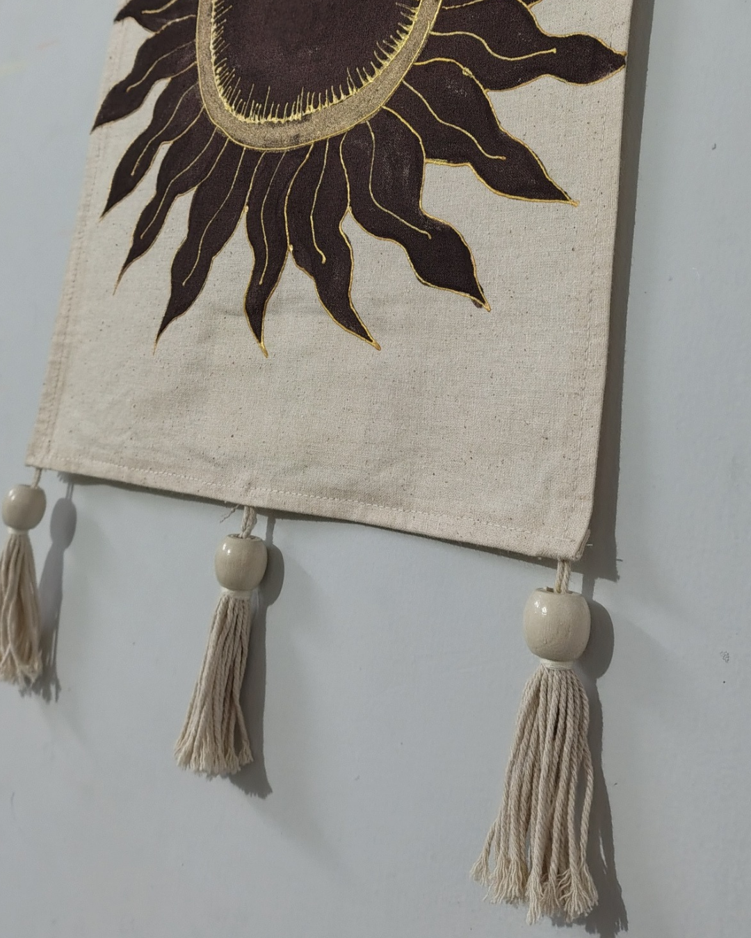 Decorative wall hanging with sun design and tassels on a plain background, hand painted room decor,